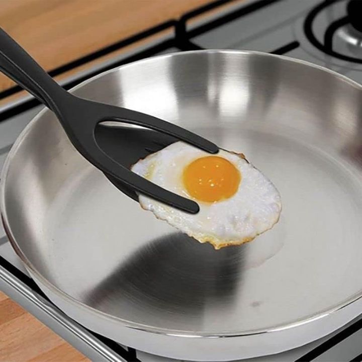 Fried egg on a spatula over a frying pan on a stove