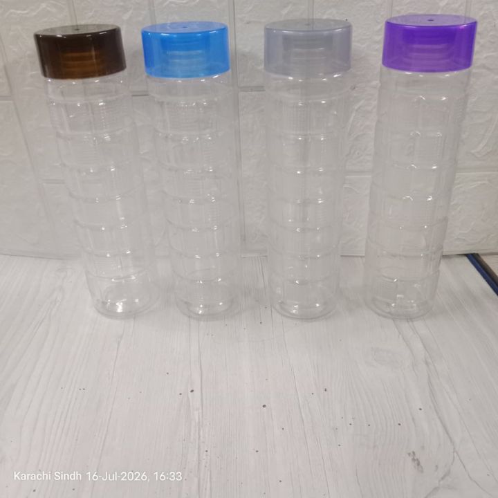 Four clear plastic water bottles with ribbed screw-on caps in brown, blue, gray, and purple, arranged on a light wood surface against a white textured wall.