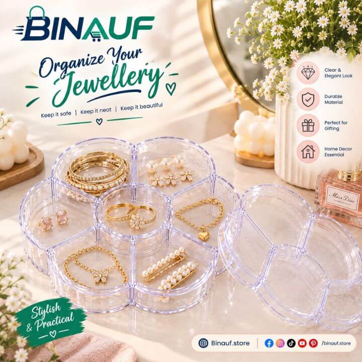 Clear plastic multi-compartment jewelry organizer tray with a hinged lid, shown open and filled with gold and pearl jewelry pieces on a styled tabletop. The Binauf brand logo and promotional text appear on the image.